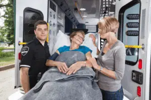 Anziana in ambulanza con medici e familiari Anziana in ambulanza con medici e familiari